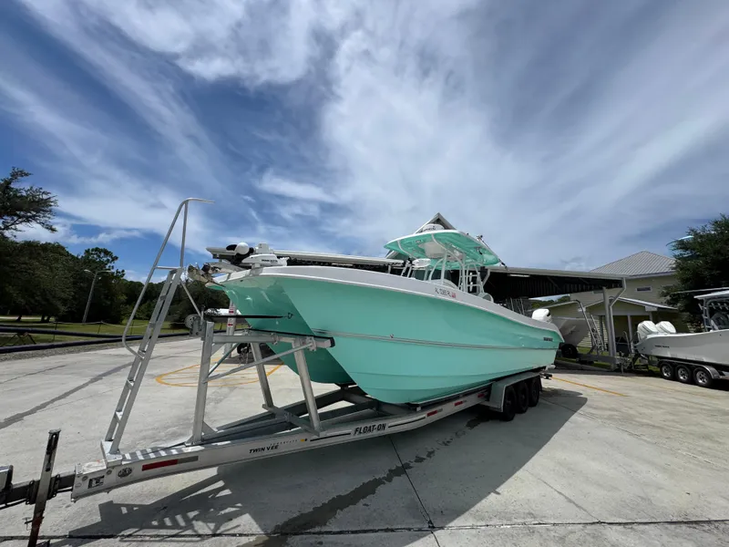 Slide: The Image of 2020 Twin Vee 310 CC GF boat on trailer under a clear blue sky. - 4