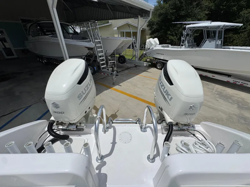 Slide: The Image of Twin Vee 310 CC GF 2020 boat with dual Suzuki 300 outboard engines in a marina. - 41