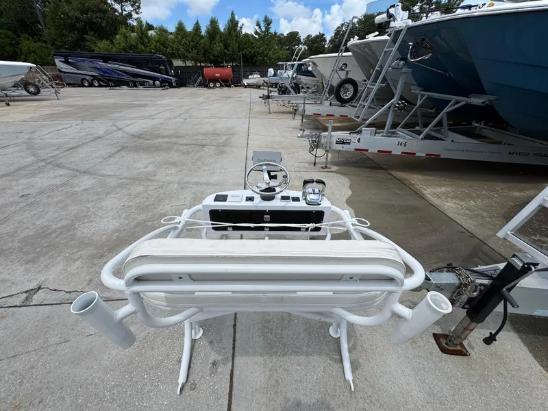 Slide: The Image of 2020 Twin Vee 310 CC GF boat console in a marina with trailers and trees. - 48