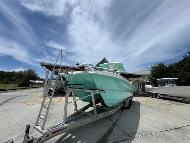 Slide: The Image of 2020 Twin Vee 310 CC GF boat on trailer under a clear blue sky. - 5
