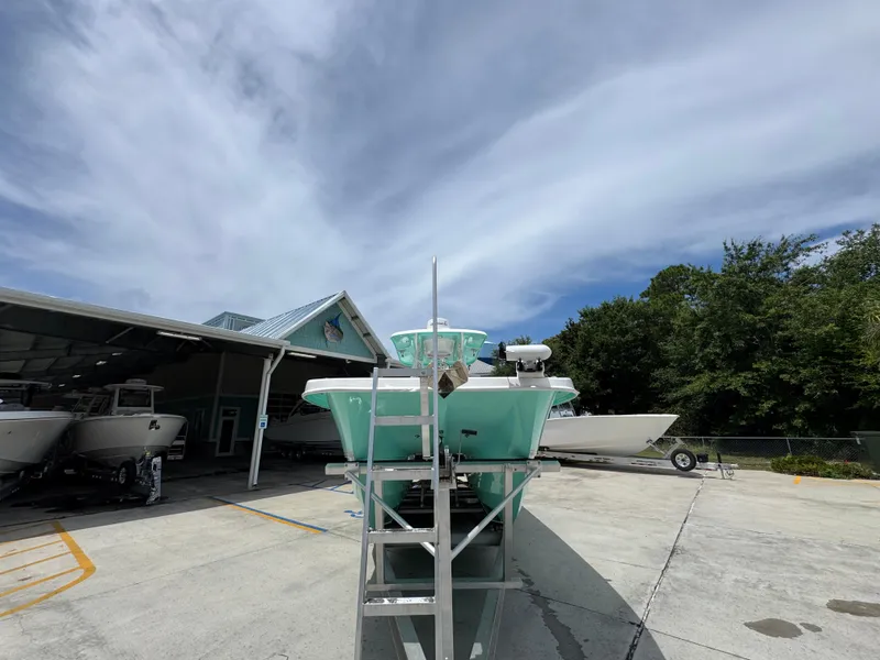 Slide: The Image of 2020 Twin Vee 310 CC GF boat on trailer, parked outdoors under a cloudy sky. - 7
