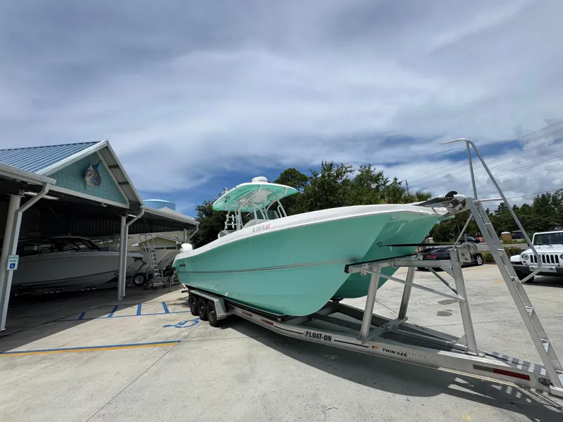Slide: The Image of 2020 Twin Vee 310 CC GF boat on trailer, parked outdoors under cloudy sky. - 9