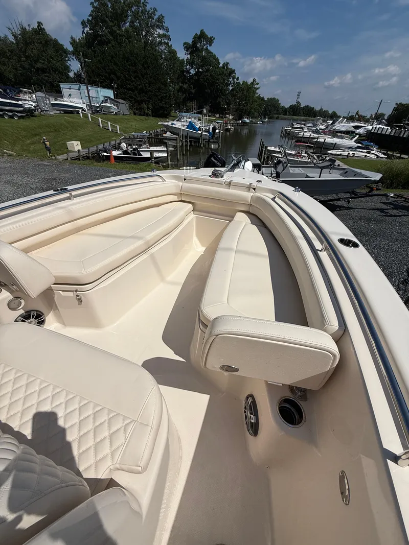 Slide: The Image of 2025 Grady-White Fisherman 257 boat interior with cream seating, docked near a marina. - 11