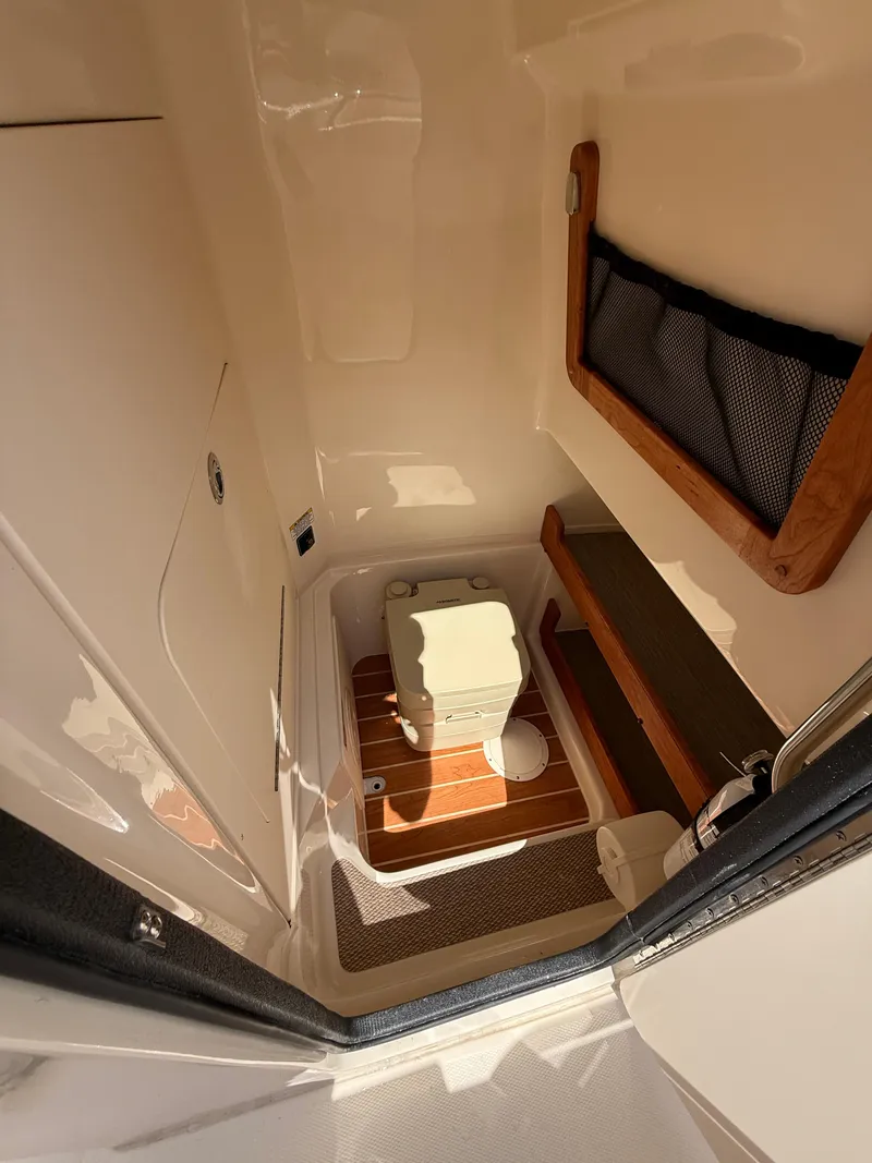 Slide: The Image of 2025 Grady-White Fisherman 257 boat interior with compact toilet and storage. - 12