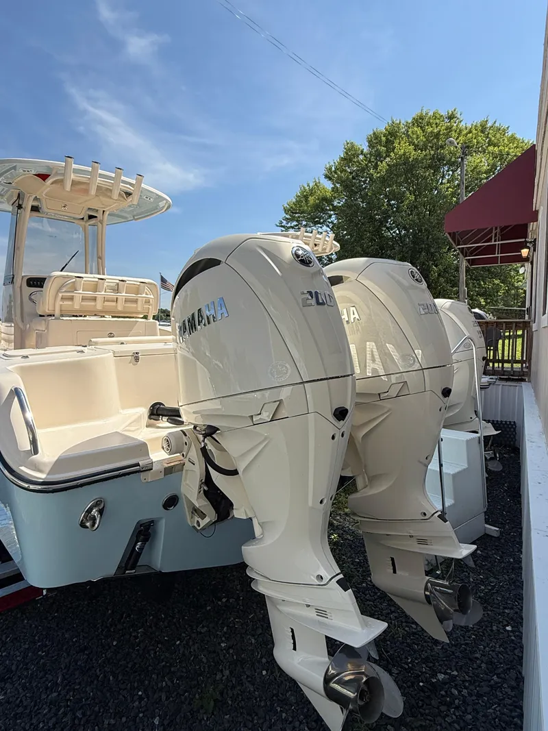 Slide: The Image of 2025 Grady-White Fisherman 257 boat with dual Yamaha outboard engines, docked under clear sky. - 3