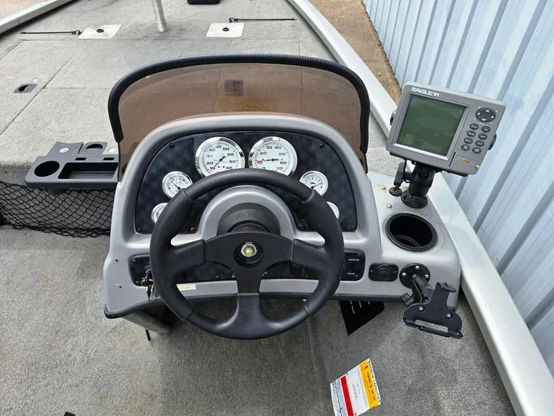 Slide: The Image of 2007 Fisher Pro Hawk 170 boat dashboard with steering wheel and gauges. - 13