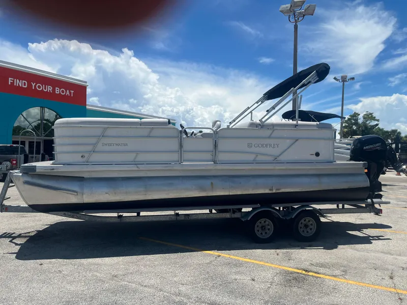 Slide: The Image of 2022 Godfrey SWEETWATER 2286 SFL pontoon boat on trailer, parked outside dealership. - 0
