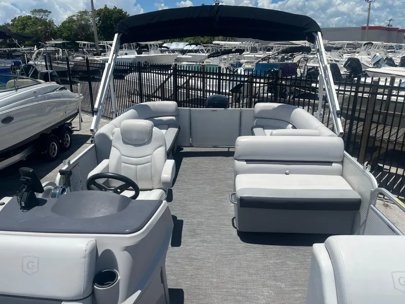 Slide: The Image of 2022 Godfrey SWEETWATER 2286 SFL pontoon boat with spacious seating and helm, docked outdoors. - 10