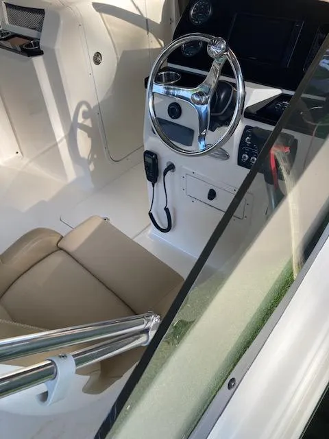 Slide: The Image of 2021 Scout 215 Dorado boat interior with steering wheel and beige seating. - 15