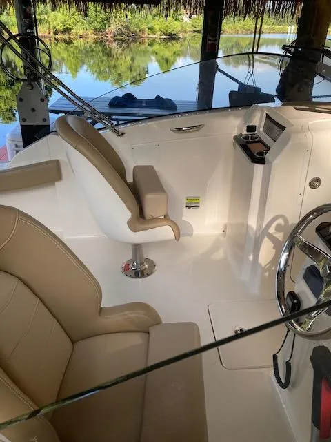 Slide: The Image of Interior of 2021 Scout 215 Dorado boat with beige seating and steering wheel. - 16