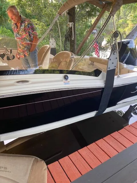 Slide: The Image of 2021 Scout 215 Dorado boat docked with a person nearby, featuring a sleek design. - 21