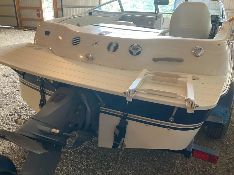 Slide: The Image of 1998 Four Winns Horizon QX boat rear view with swim platform and ladder in a garage. - 5