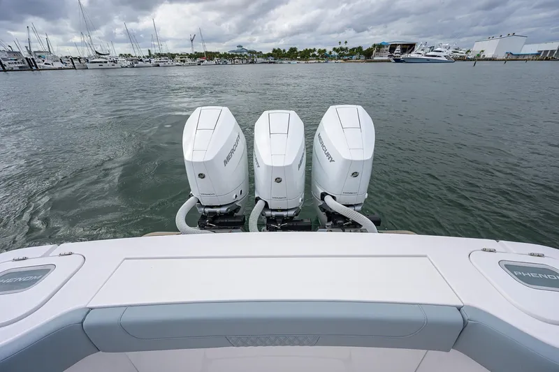 Slide: The Image of 2026 Phenom 37 Center Console with triple Mercury outboard engines on a calm marina. - 42