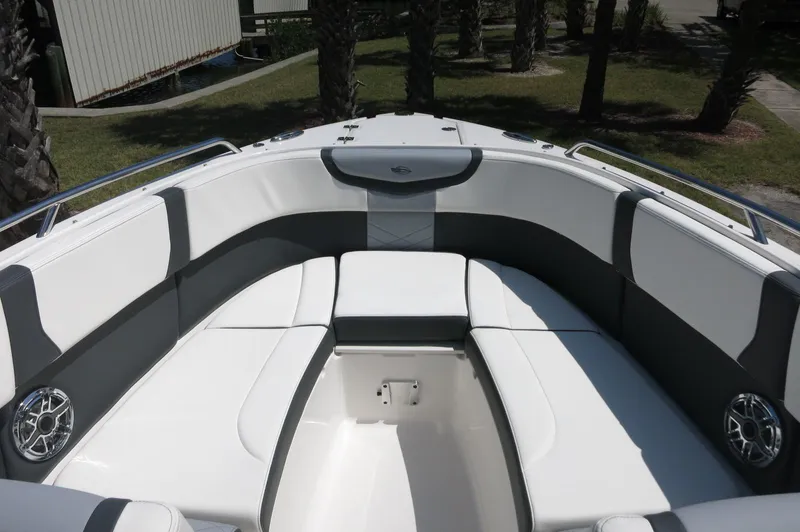 Slide: The Image of 2025 Chaparral 270 OSX boat interior with white and gray seating, outdoor setting. - 13