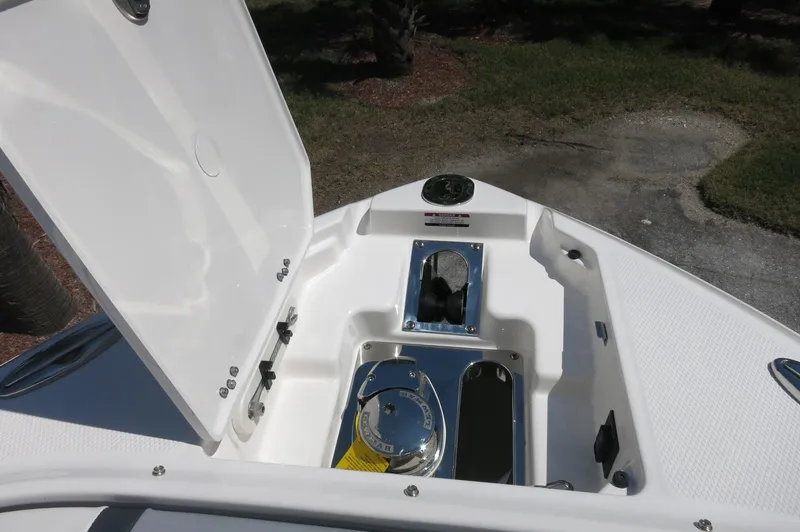 Slide: The Image of 2025 Chaparral 270 OSX boat anchor compartment with open hatch, showcasing sleek design. - 14
