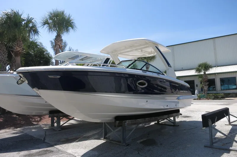 Slide: The Image of 2025 Chaparral 270 OSX boat displayed outdoors, featuring sleek design and modern structure. - 2