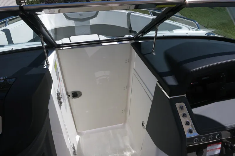 Slide: The Image of 2025 Chaparral 270 OSX boat interior with open cabin door and dashboard controls. - 22