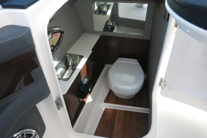 Slide: The Image of 2025 Chaparral 270 OSX boat interior with sink, toilet, and mirror. - 24