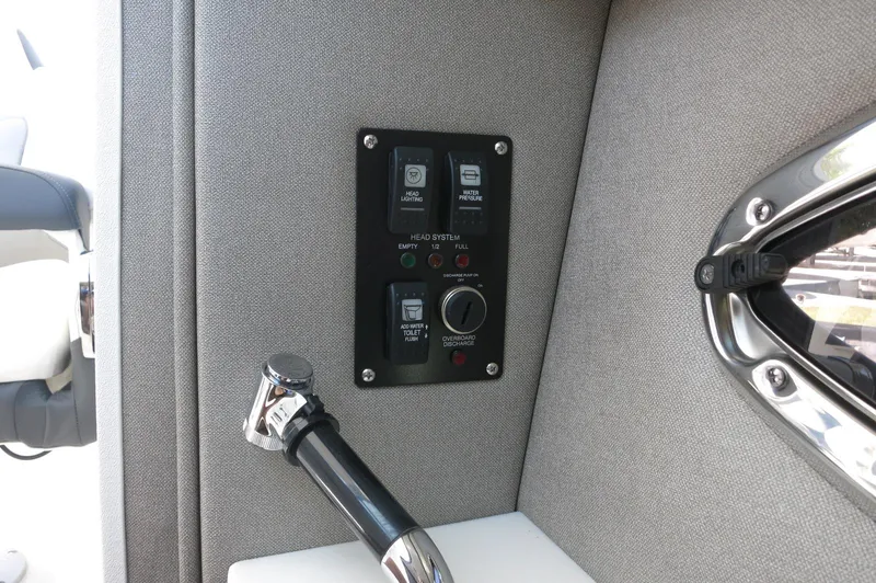 Slide: The Image of Control panel on 2025 Chaparral 270 OSX boat interior, featuring head system and water pressure controls. - 25
