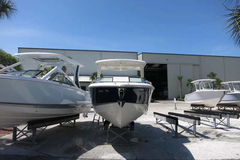 Slide: The Image of 2025 Chaparral 270 OSX boat displayed outdoors near a warehouse. - 3