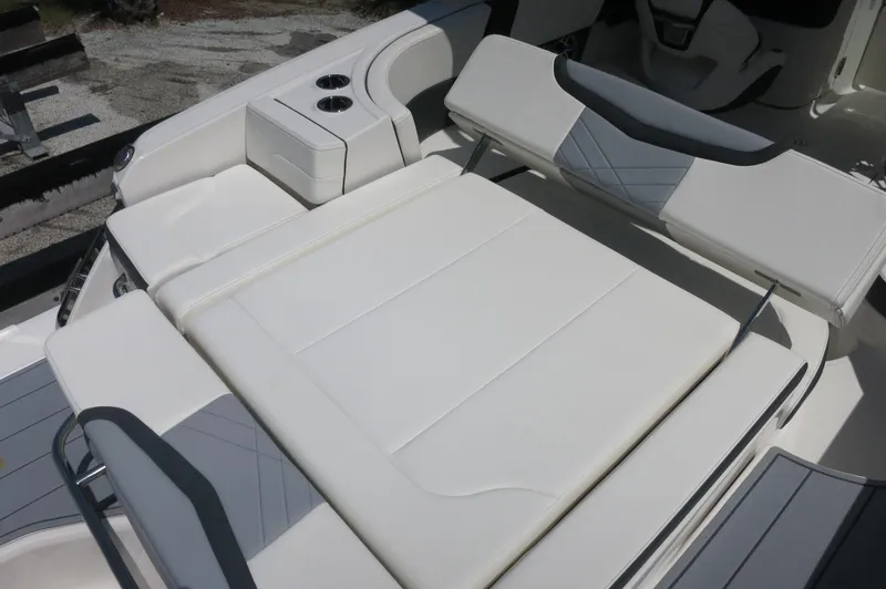 Slide: The Image of 2025 Chaparral 270 OSX boat interior with white cushioned seating and cup holders. - 36