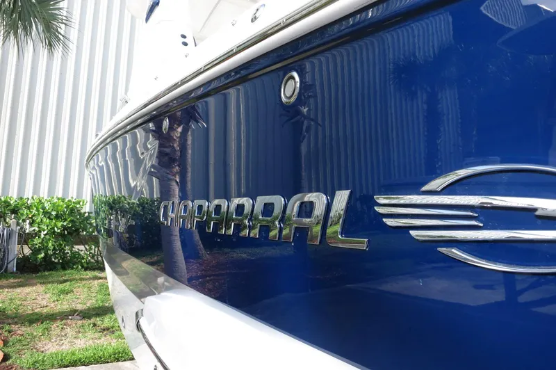 Slide: The Image of Chaparral 270 OSX 2025 boat with sleek blue exterior and chrome logo. - 44