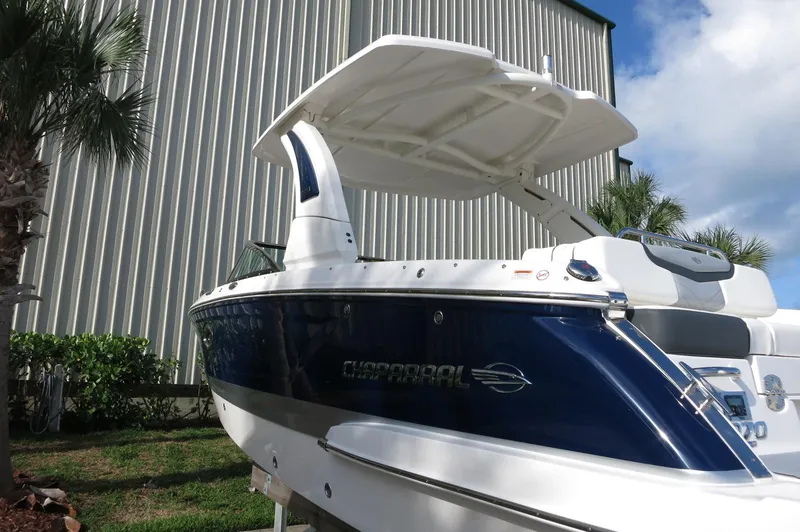 Slide: The Image of 2025 Chaparral 270 OSX boat with sleek design, docked near palm trees. - 45