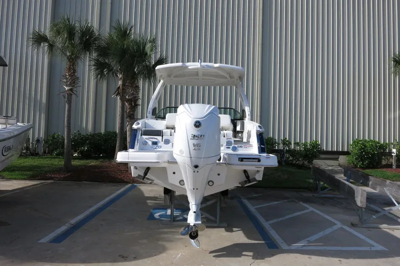 Slide: The Image of 2025 Chaparral 270 OSX boat parked outdoors near palm trees. - 46