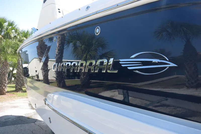Slide: The Image of 2025 Chaparral 270 OSX boat with logo, reflecting palm trees. - 7
