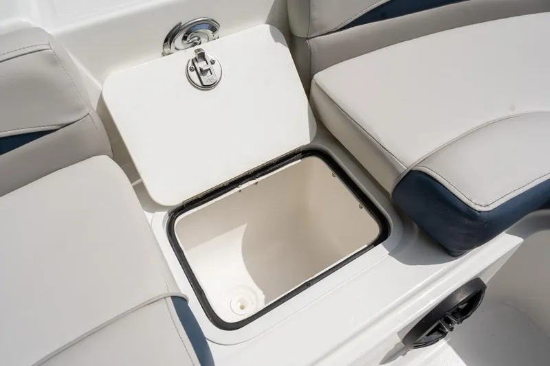 Slide: The Image of 2025 Hurricane SunDeck 217 OB boat storage compartment with open lid and cushioned seating. - 17