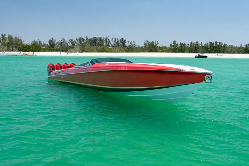Slide: The Image of 2023 Nor-Tech 55 Flyer boat on turquoise water near a sandy beach. - 13