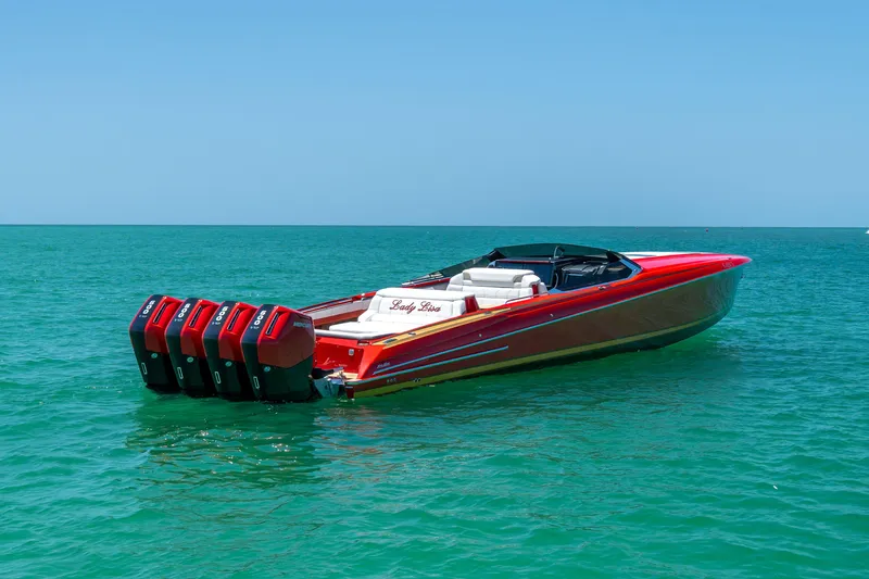 Slide: The Image of 2023 Nor-Tech 55 Flyer boat with red exterior on clear blue water. - 16