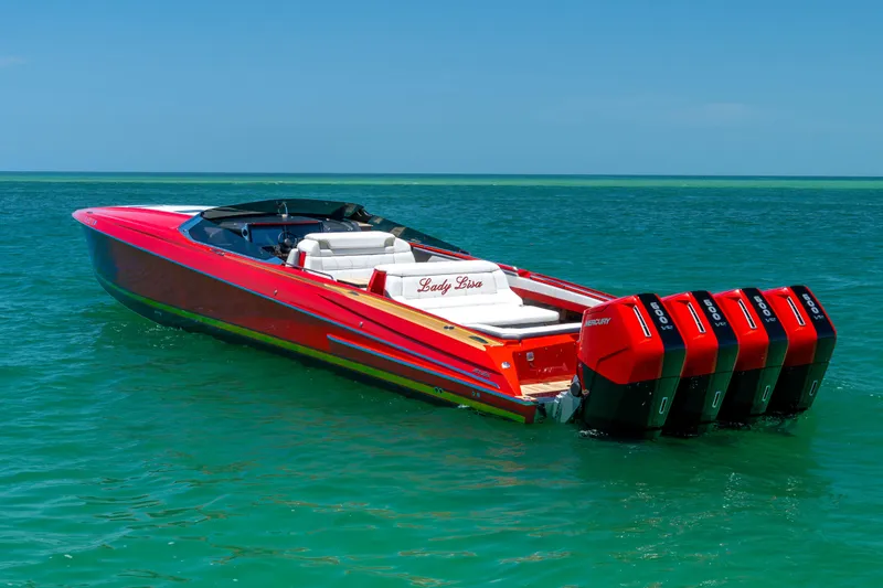 Slide: The Image of 2023 Nor-Tech 55 Flyer speedboat with red exterior and multiple outboard engines on clear water. - 19