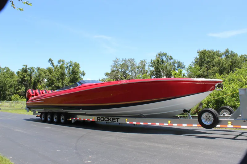 Slide: The Image of 2023 Nor-Tech 55 Flyer boat on trailer, vibrant red, parked outdoors. - 20