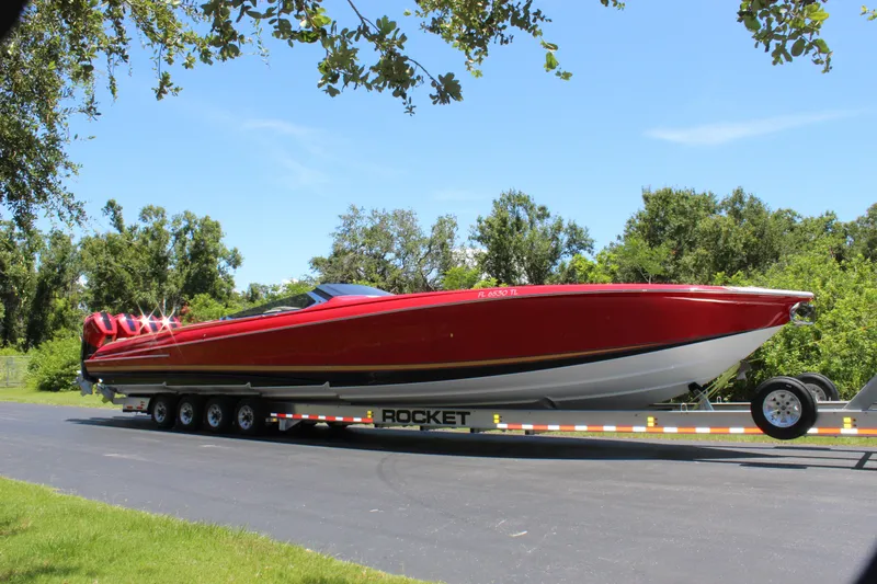 Slide: The Image of 2023 Nor-Tech 55 Flyer boat on trailer, vibrant red, parked outdoors. - 22