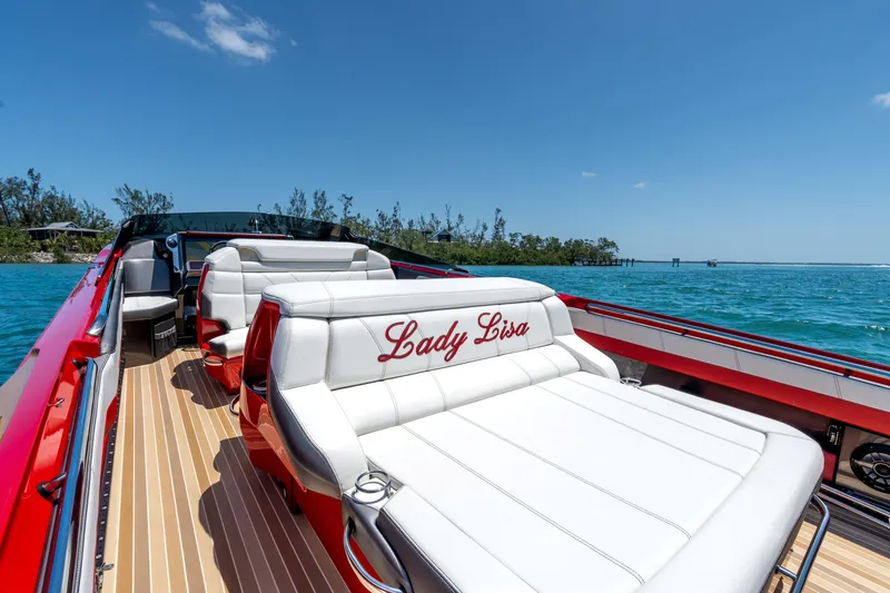 Slide: The Image of 2023 Nor-Tech 55 Flyer luxury boat with white seating, red accents, and "Lady Lisa" embroidery. - 34