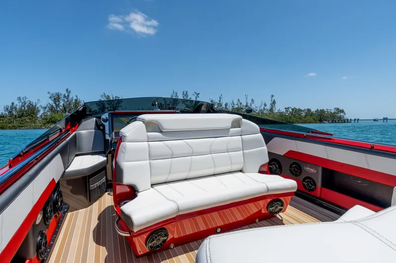 Slide: The Image of 2023 Nor-Tech 55 Flyer luxury boat interior with white seating and red accents on a sunny day. - 37