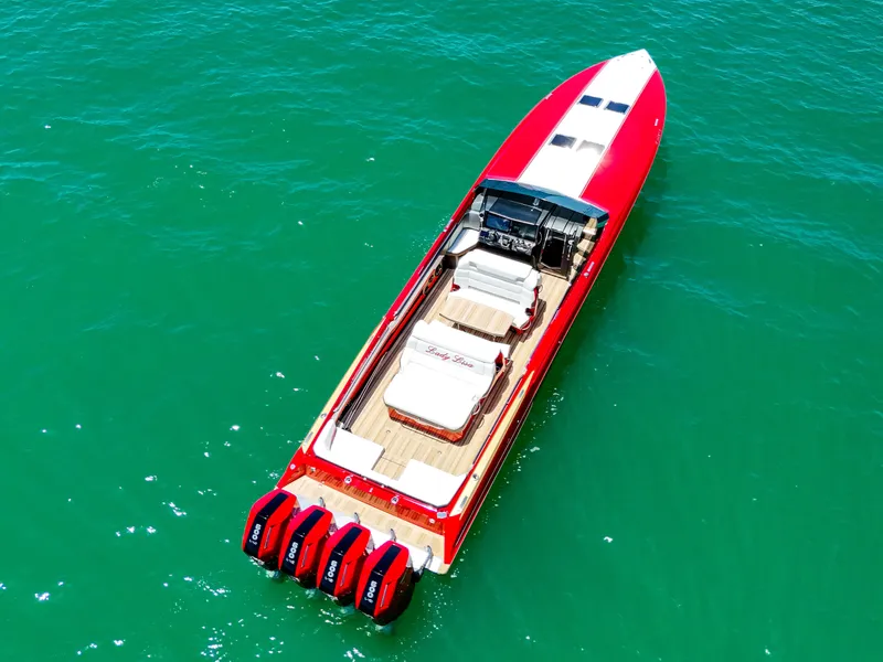 Slide: The Image of 2023 Nor-Tech 55 Flyer boat with red exterior on clear green water. - 7