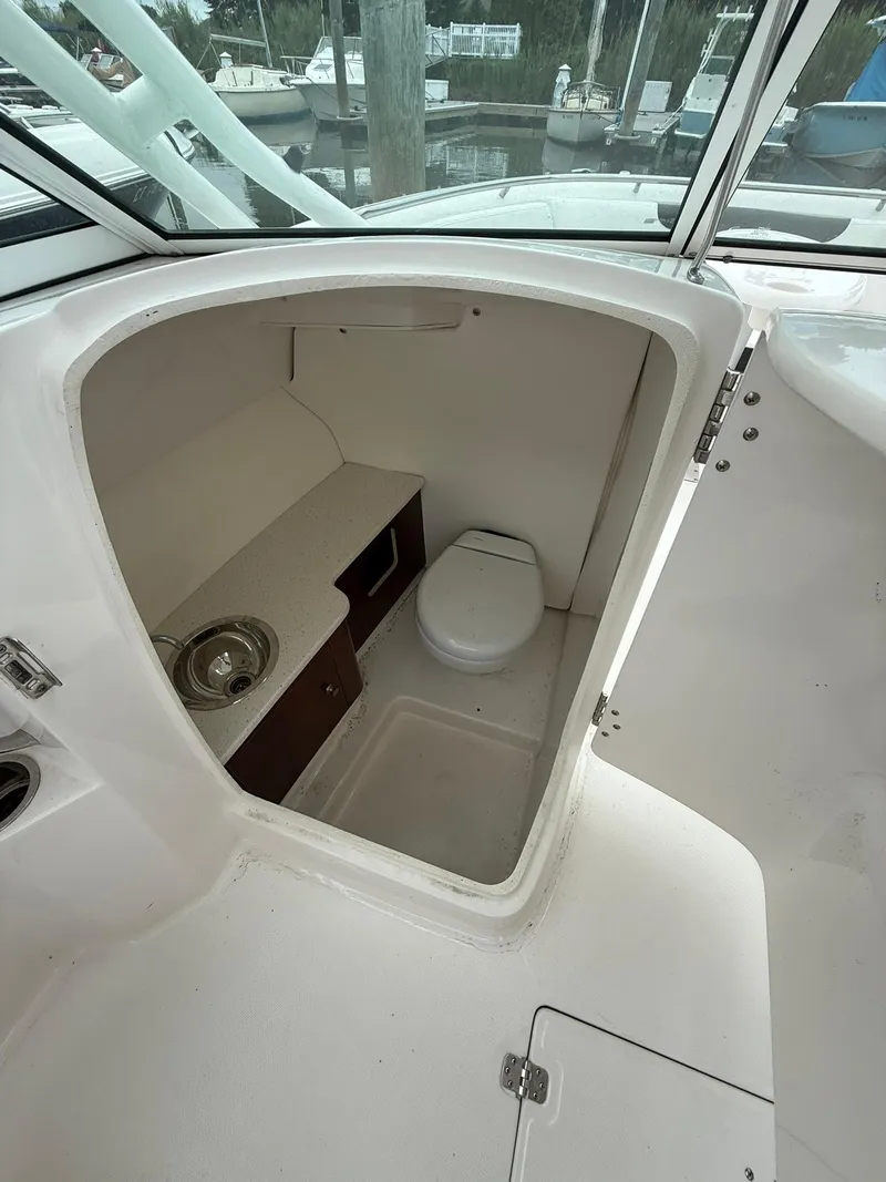 Slide: The Image of 2022 Robalo R247 Dual Console boat interior with compact bathroom amenities. - 10