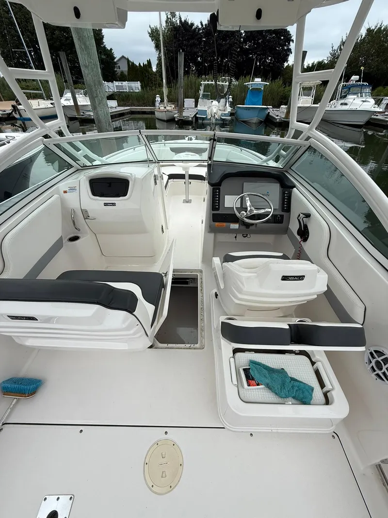 Slide: The Image of 2022 Robalo R247 Dual Console boat interior with seating and steering wheel. - 11