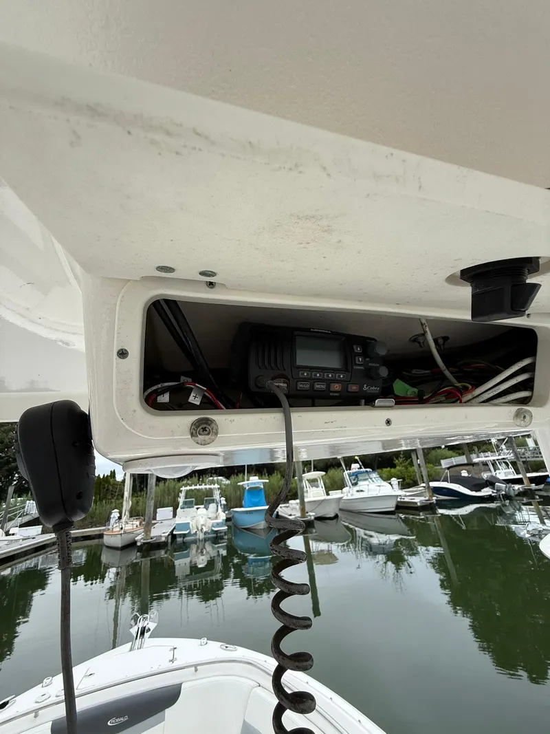 Slide: The Image of 2022 Robalo R247 Dual Console boat with radio equipment in storage compartment. - 13