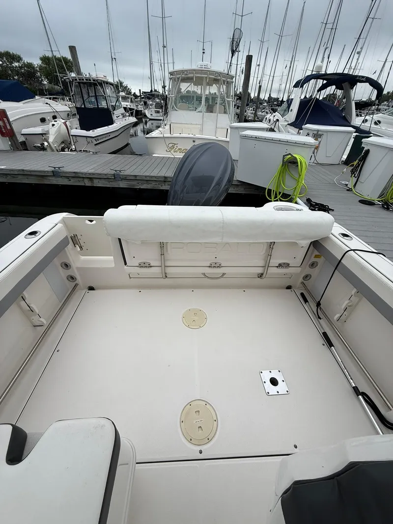 Slide: The Image of 2022 Robalo R247 Dual Console boat interior at marina, showcasing spacious deck and seating. - 3