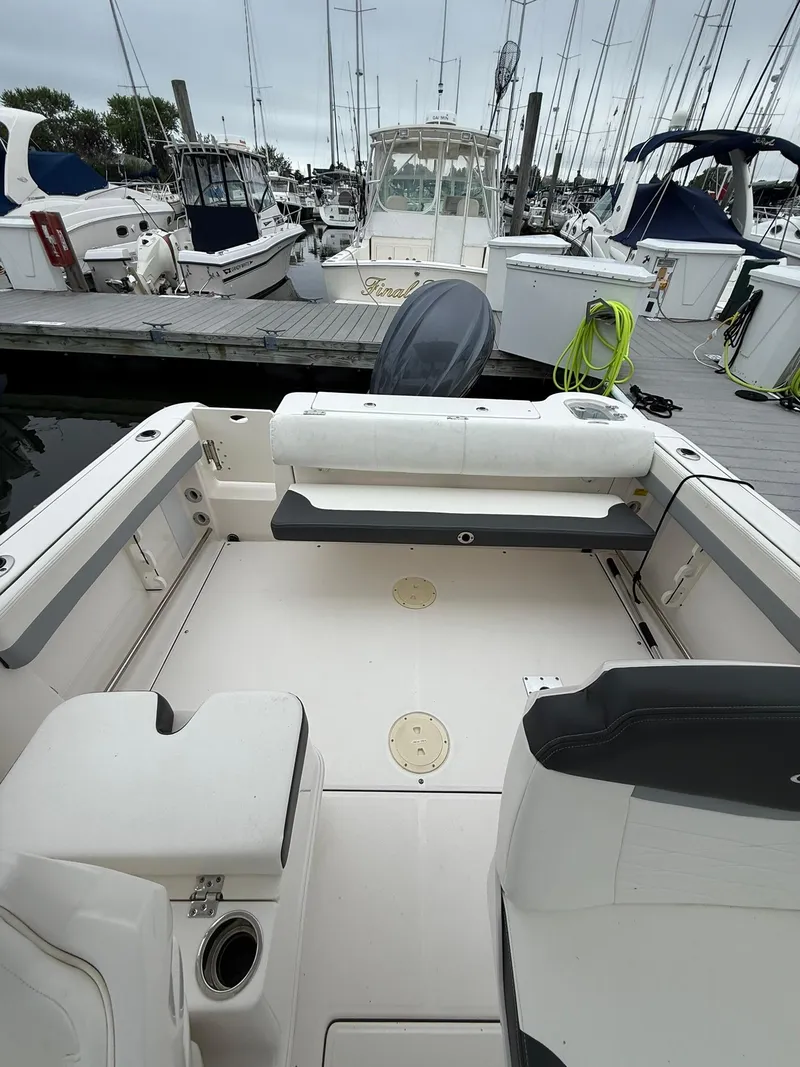 Slide: The Image of 2022 Robalo R247 Dual Console boat docked at marina, featuring spacious seating area. - 5