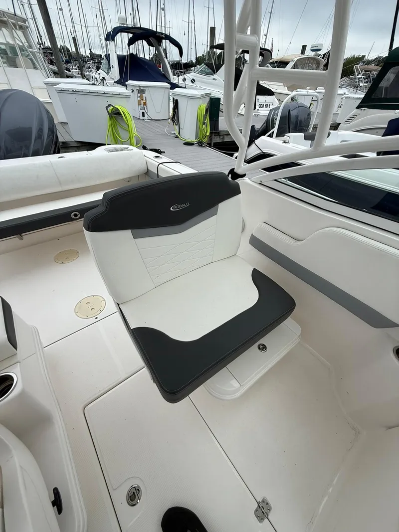 Slide: The Image of 2022 Robalo R247 Dual Console boat interior with seating, docked at marina. - 6