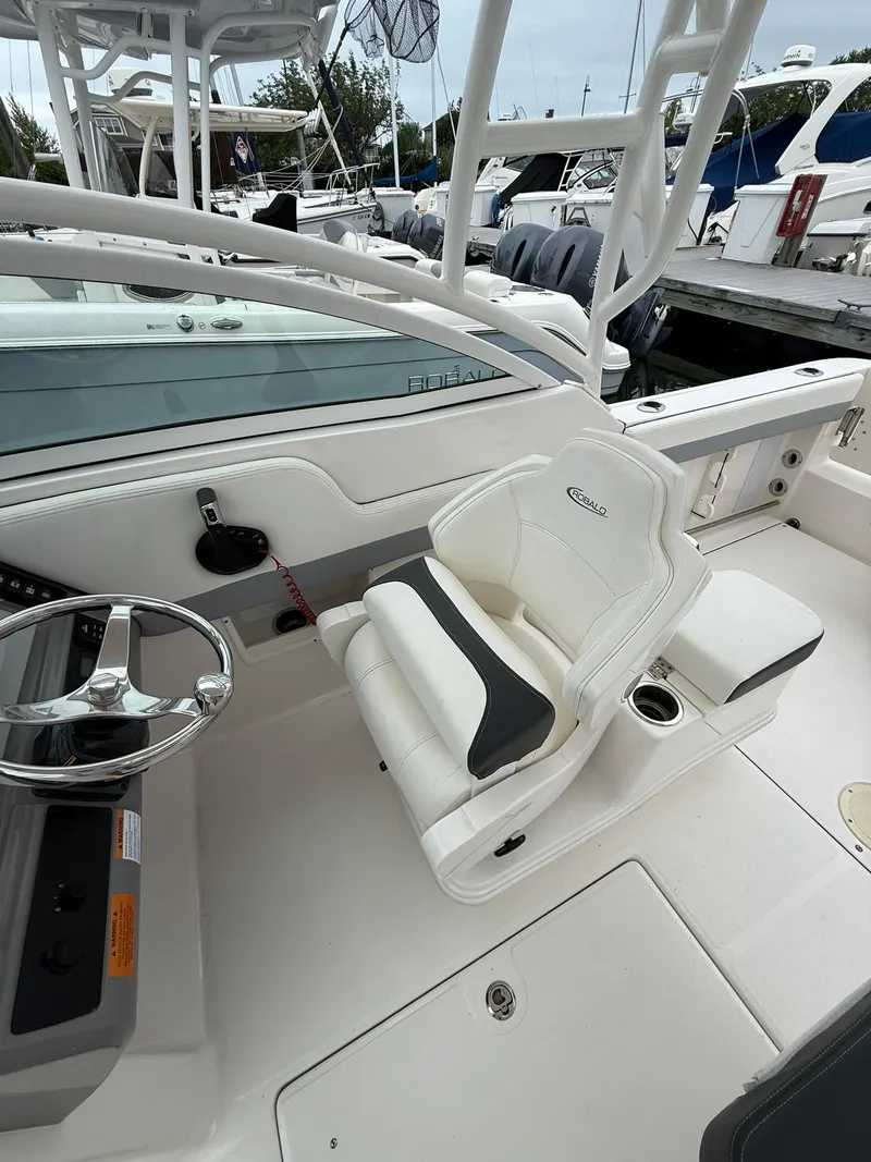 Slide: The Image of 2022 Robalo R247 Dual Console boat interior with steering wheel and seating. - 7