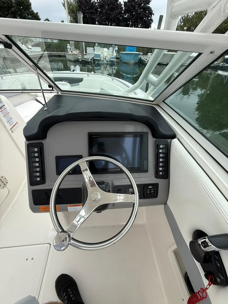 Slide: The Image of 2022 Robalo R247 Dual Console helm with steering wheel and control panel. - 8