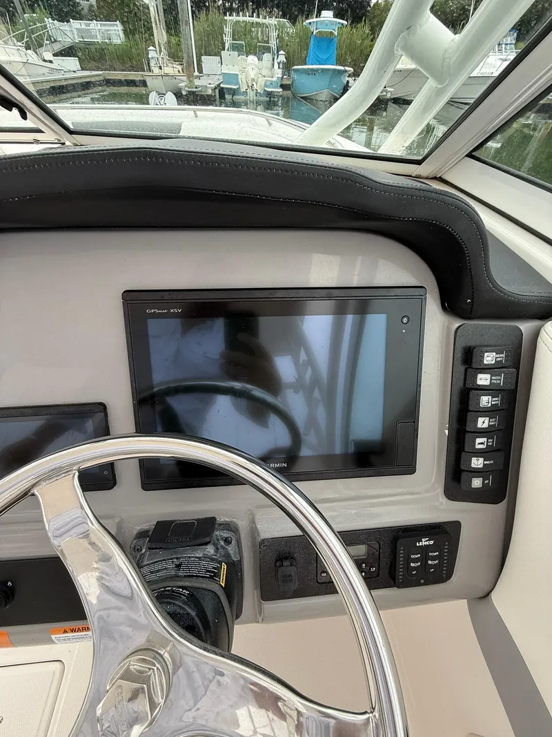 Slide: The Image of 2022 Robalo R247 Dual Console helm with Garmin GPS, steering wheel, and control panel. - 9
