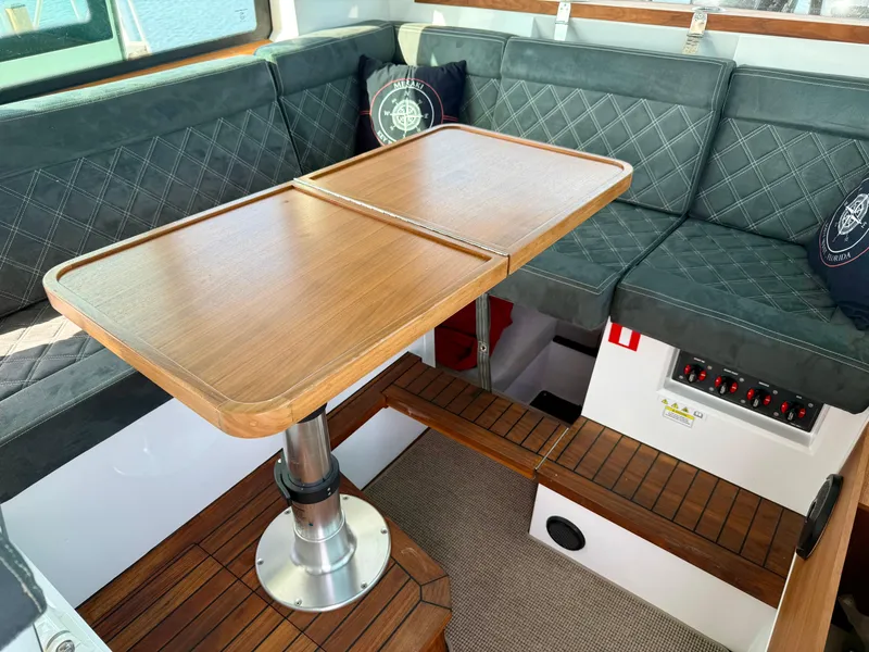 Slide: The Image of Interior of 2019 Axopar AX37XC boat with wooden table and cushioned seating. - 23