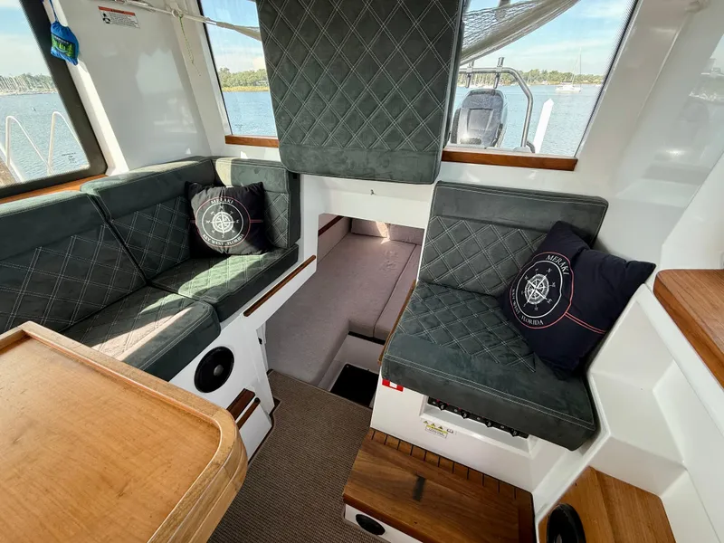 Slide: The Image of 2019 Axopar AX37XC interior with cushioned seating and nautical-themed pillows. - 24