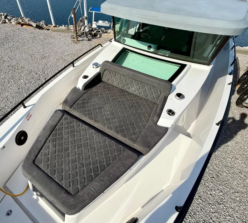Slide: The Image of 2019 Axopar AX37XC boat with cushioned seating, docked by the water. - 7
